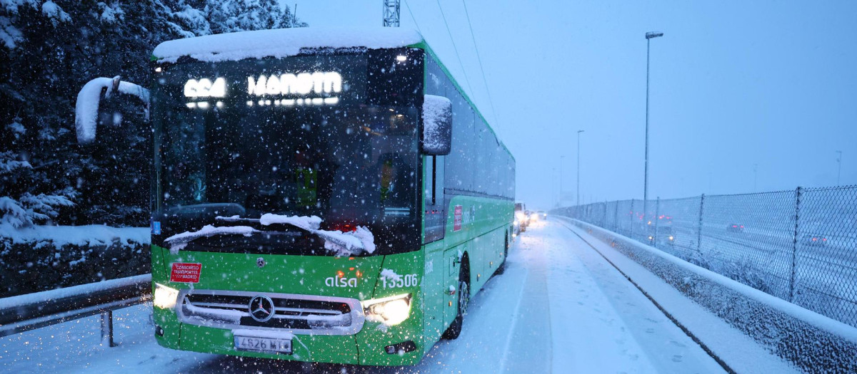Vista de un autobús interurbano cubierto de nieve en Torrelodones, Madrid, este miércoles