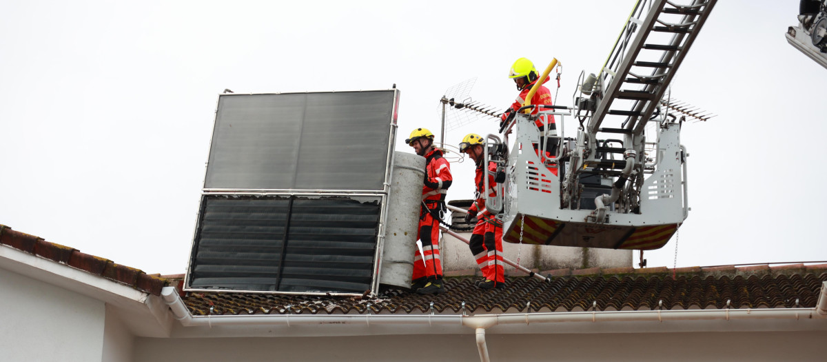 Bomberos de Sevilla proceden a retirar un panel solar de una casa por las fuertes rachas de viento
