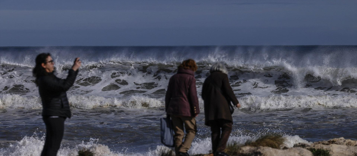 Imagen de archivo de varias personas frente al  mar durante la borrasca Harry en la localidad valenciana de Tavernes de la Valldigna