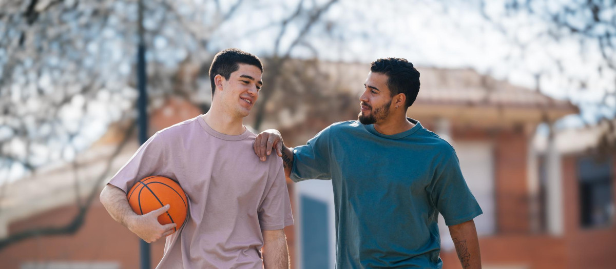 Dos jóvenes charlando tras jugar a baloncesto, en una imagen de archivo