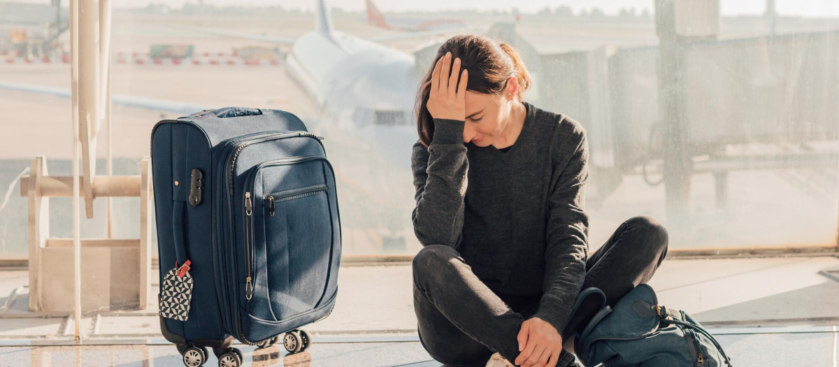 Sad (tired) woman sitting in the airport - missed or cancelled flight concept.