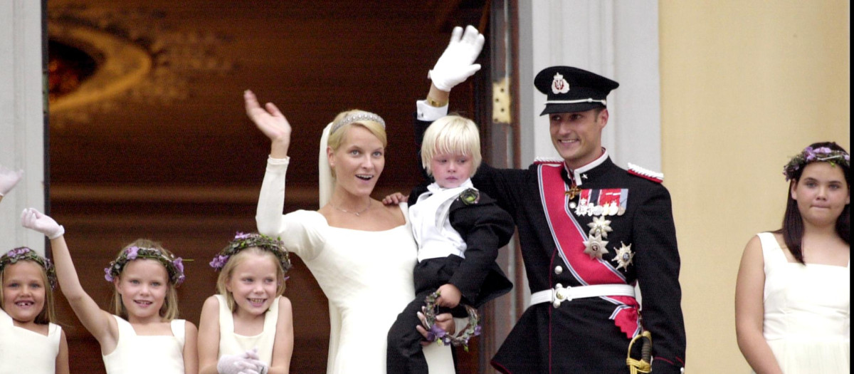 Los Príncipes Haakon y Mette Marit, recién casados, saludan desde el balcón del Palacio Real con Marius en brazos
