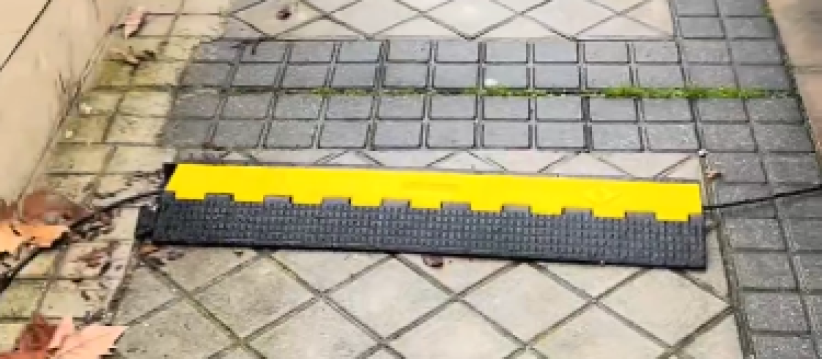 Así protege el dueño su cable sobre la acera