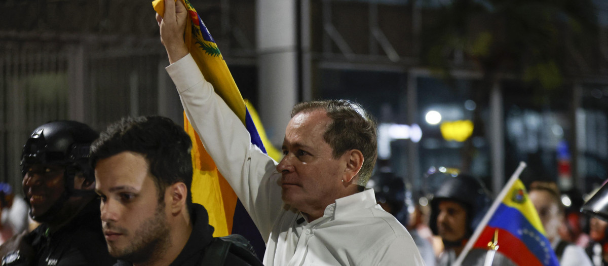 El opositor Juan Pablo Guanipa sostiene la bandera de Venezuela durante las horas que ha sido excarcelado