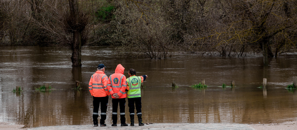 Tres agentes del SAMUR observan el parking de Somontes inundado, a 21 de marzo de 2025, en Madrid (España)