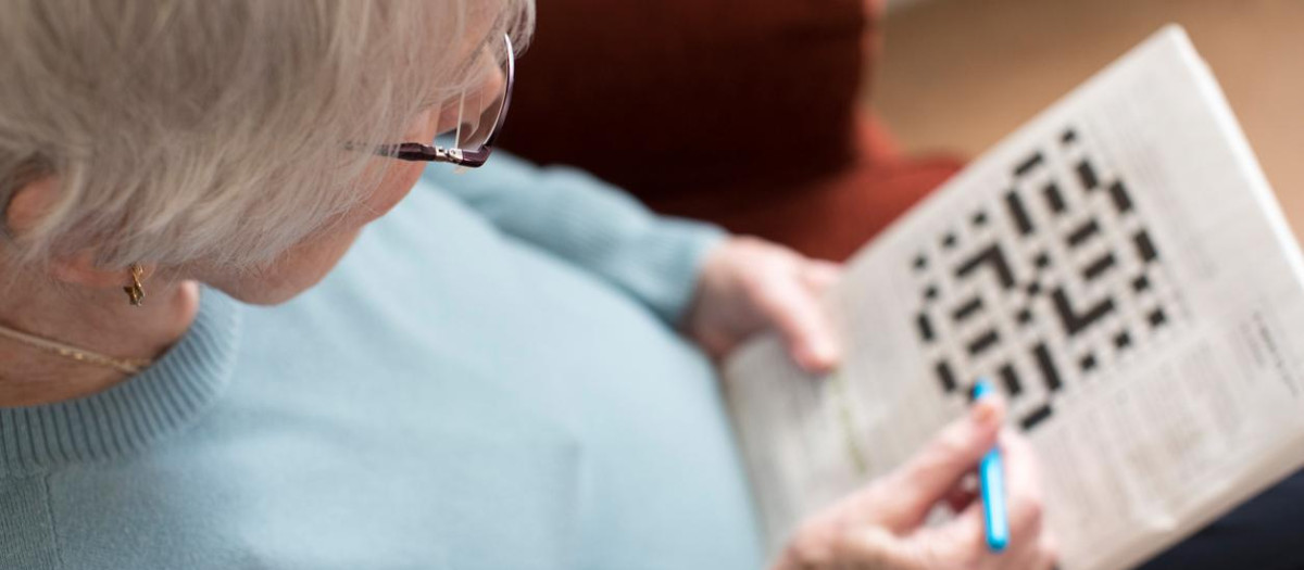 Senior Woman Doing Crossword Puzzle At Home