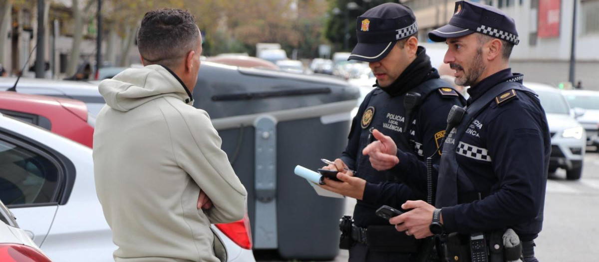 Imagen de archivo de dos agentes de la Policía Local de Valencia multando a un gorrilla.