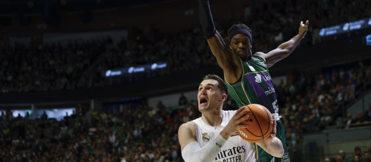 El alero croata del Real Madrid Mario Hezonja (i) se escapa de Kendrick Perry, de Unicaja, durante el partido de Liga Endesa