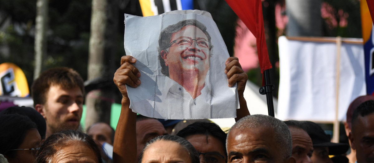 Un partidario del candidato presidencial colombiano por el Pacto Histórico, Iván Cepeda, muestra un retrato del presidente colombiano Gustavo Petro durante un mitin en Medellín, Colombia