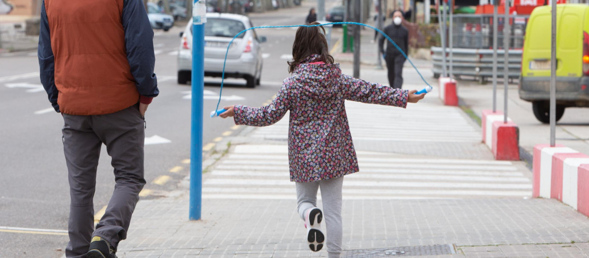 Una niña salta a la comba junto a su padre en una calle de Zamora