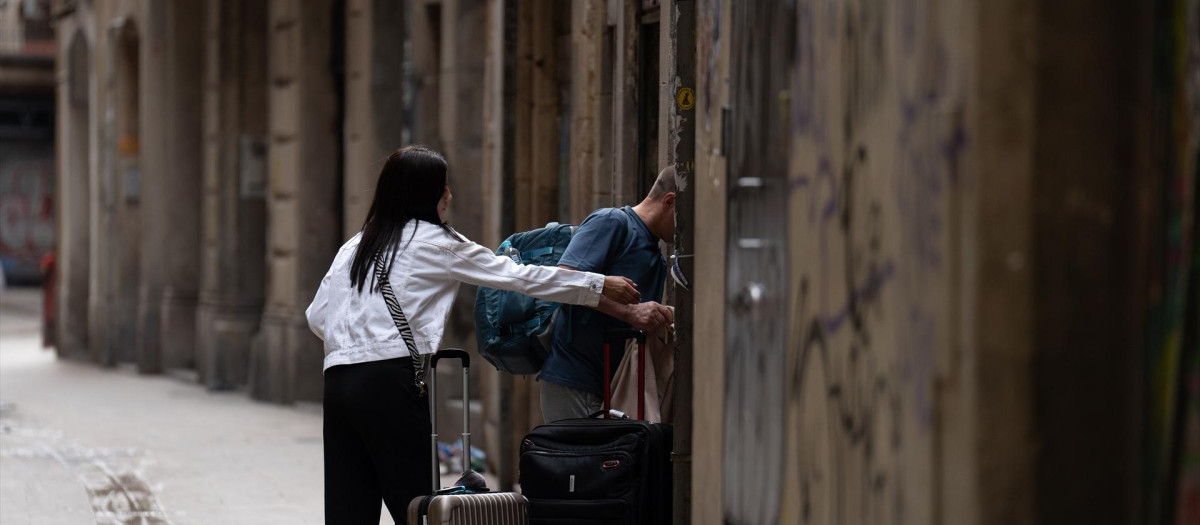 Dos turistas con maletas en el centro de Barcelona.