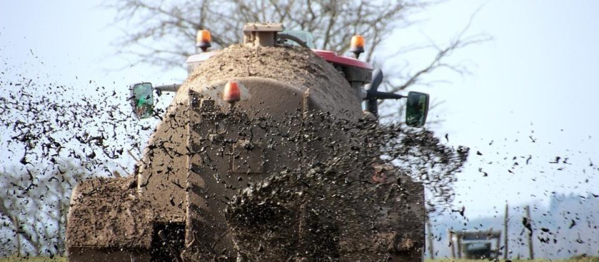 Un tractor arroja purines al campo