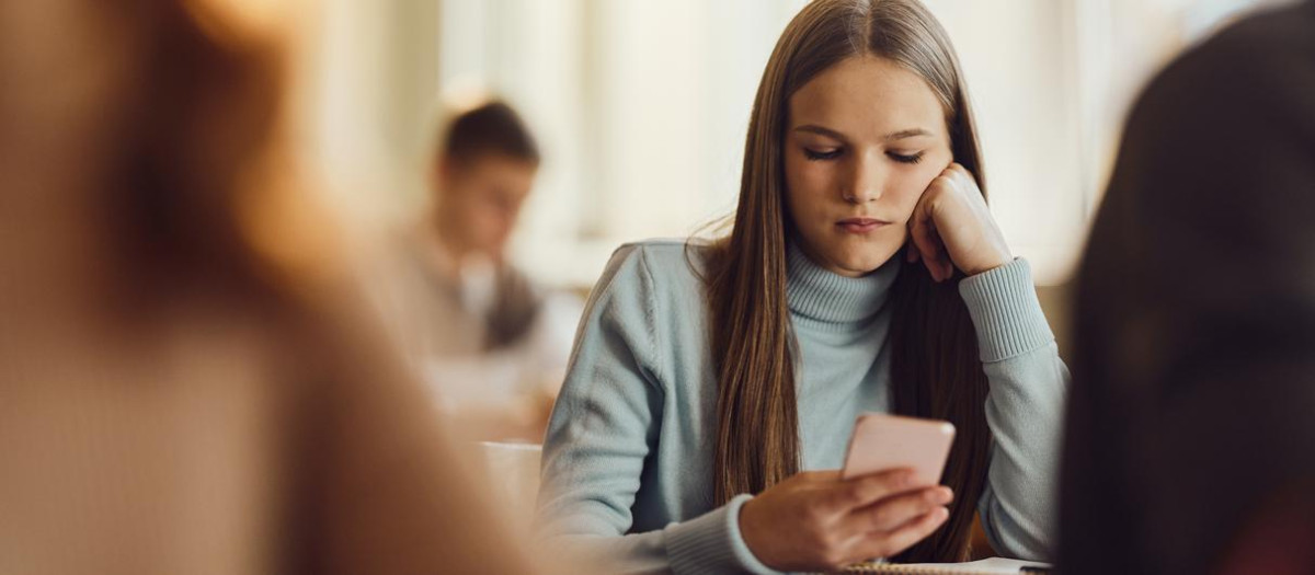 Estudiante con el móvil en clase
