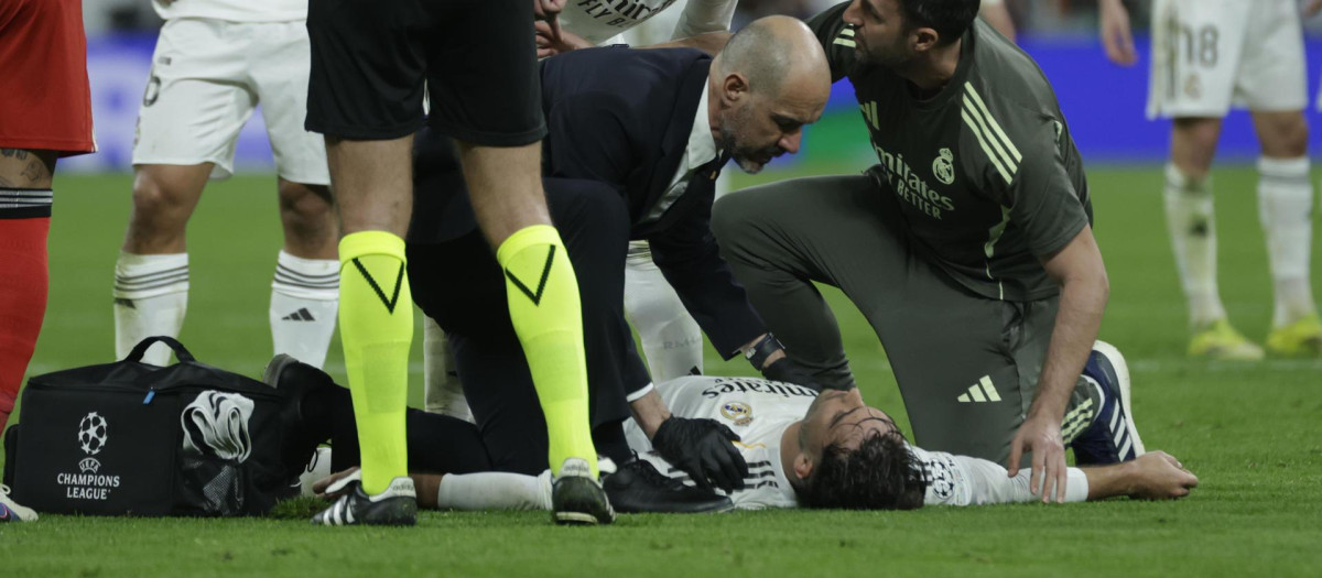 El defensa del Real Madrid Raúl Asencio (en el suelo) es atendido durante el Real Madrid - Benfica