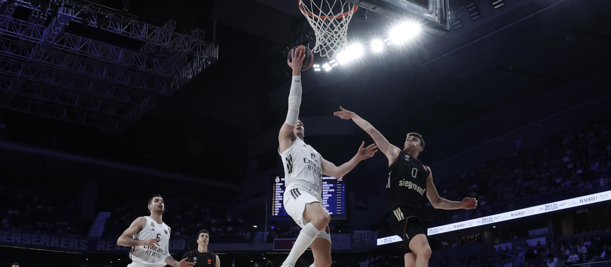 MADRID, 26/02/2026.- El jugador del Real Madrid Mario Hezonja (c) entra a canasta durante el partido de la Euroliga disputado este jueves ante el Bayern Munich en el Movistar Arena, en Madrid. EFE/Juanjo Martín