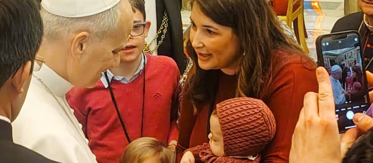 El pequeño León, en brazos de su madre, agarra la mano del Papa León