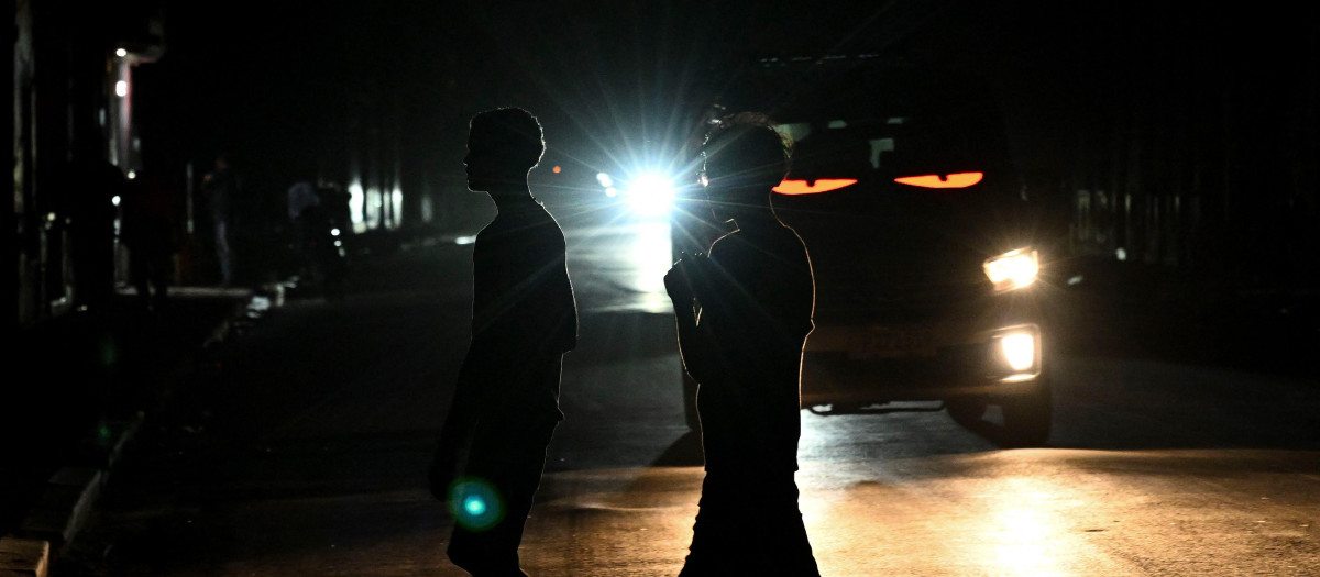 La gente cruza una calle oscura durante un apagón en La Habana