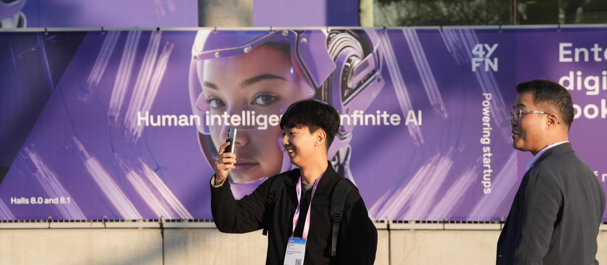 Un asistente al MWC 2026 utiliza un smartphone