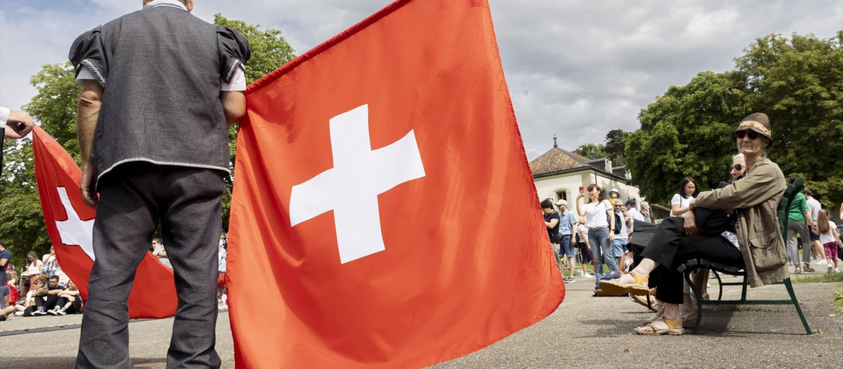 Un hombre con una bandera de Suiza.
