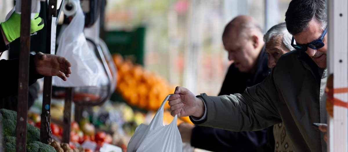 Personas comprando en una frutería.