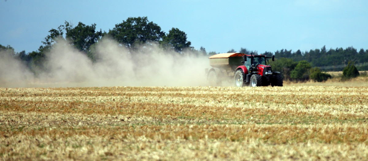 Un agricultor aplica fertilizantes con el tractor