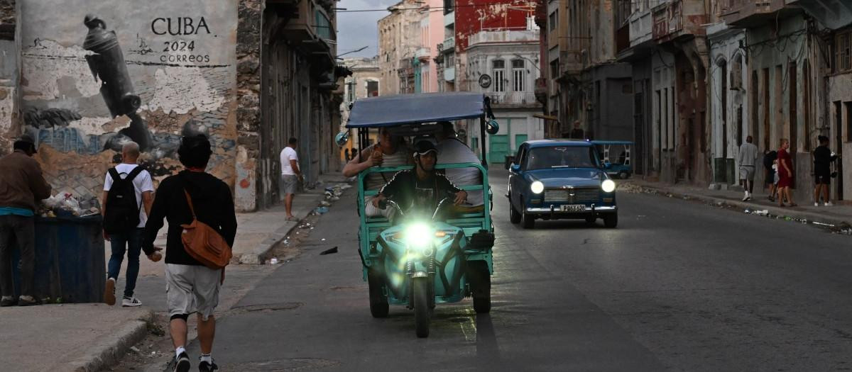 Personas transitan por una calle sin luz durante un apagón nacional en La Habana el 21 de marzo de 2026