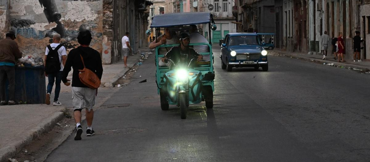 Personas transitan por una calle sin luz durante un apagón nacional en La Habana el 21 de marzo de 2026