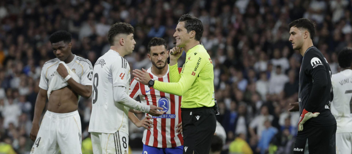 Munuera Montero conversa con Fede Valverde (2-i) tras haberle expulsado en el derbi