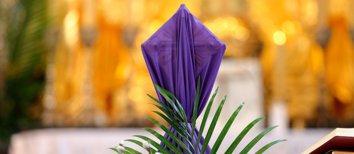 Cruz cubierta con tela morada en el altar durante la Cuaresma y la Semana Santa.