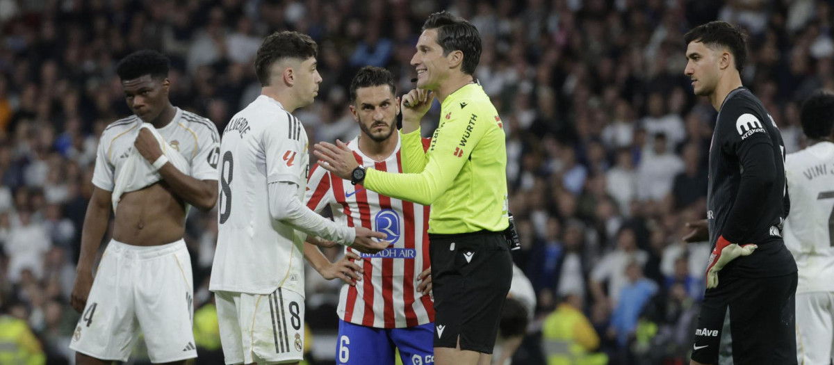 El árbitro Munuera Montero (2-d) conversa con el centrocampista del Real Madrid Fede Valverde (2-i) tras haberle sacado la tarjeta roja