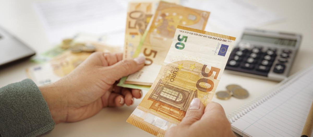 Una persona con varios billetes en su mano