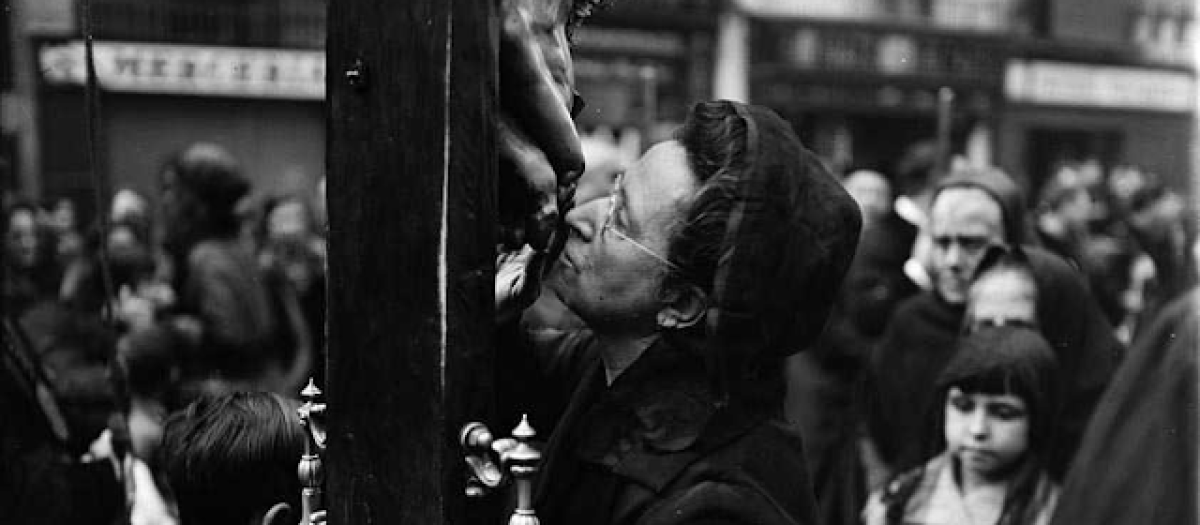 Una mujer adorando al Santo Cristo en Viernes Santo, en Barcelona, en 1930