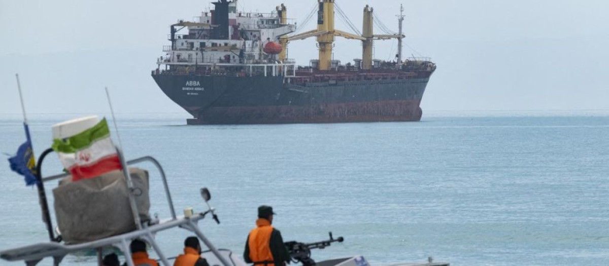 Una lancha rápida del Cuerpo de la Guardia Revolucionaria Islámica navega por el Golfo Pérsico cerca de un buque de carga general