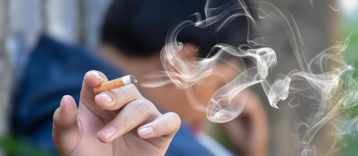 Cigarro encendido en la mano