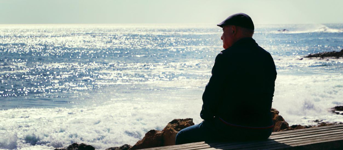Porto, Portugal - October 20. 2018: Old man sit on bench by the Atlantic ocean view.