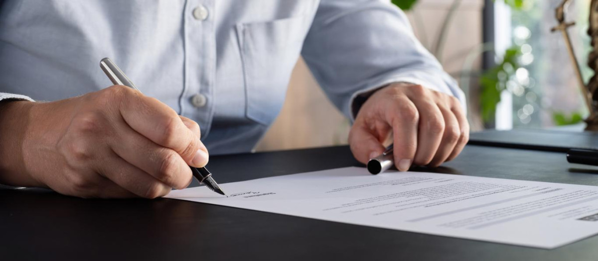 Lawyer signing an official document in the office