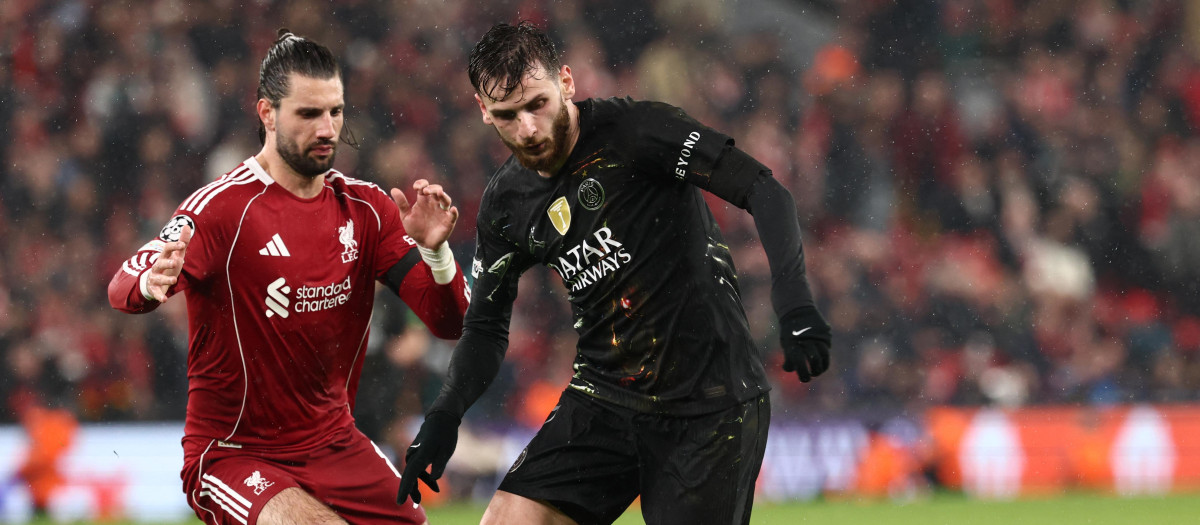 Paris Saint-Germain's Georgian forward #07 Khvicha Kvaratskhelia is put under pressure by Liverpool's Hungarian midfielder #08 Dominik Szoboszlai during the UEFA Champions League quarter final, second-leg football match between Liverpool and Paris Saint-Germain at Anfield in Liverpool, north west England on April 14, 2026. (Photo by FRANCK FIFE / AFP)