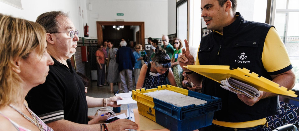 Trabajador de Correos entrega el voto por correo durante las elecciones generales de 2023 en una mesa electoral de Madrid