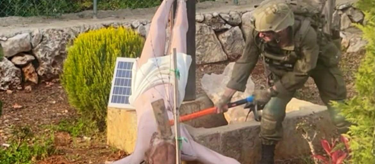 Un soldado israelí golpeando con un martillo una figura de Cristo en el Líbano