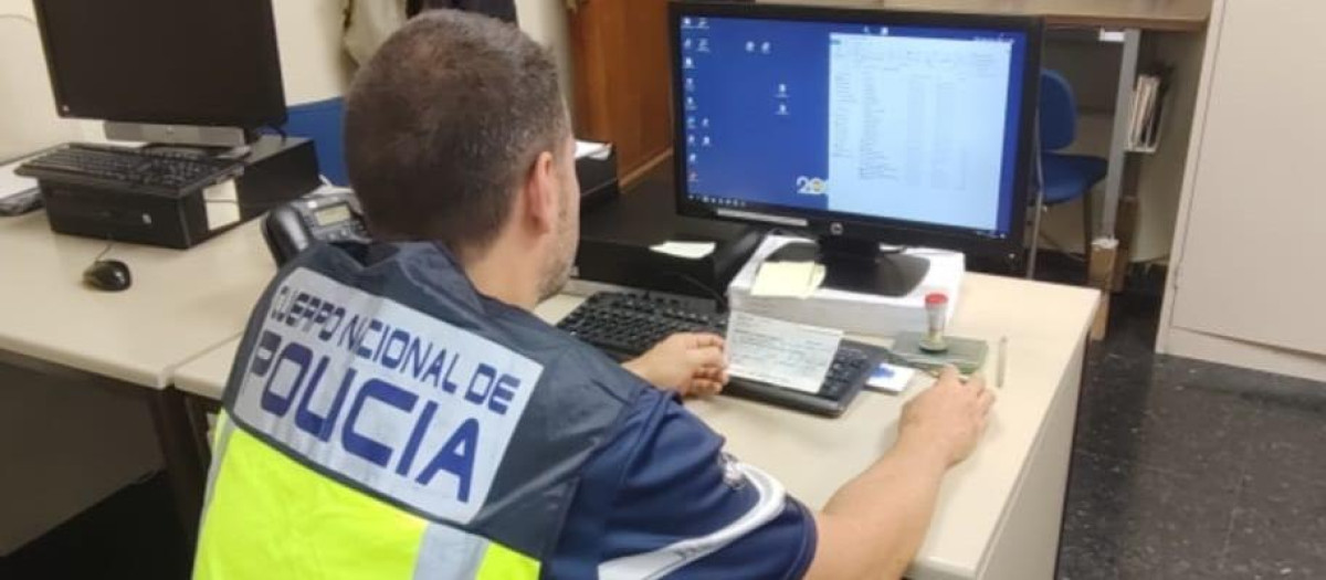 Un agente de Policía Nacional frente a un ordenador.