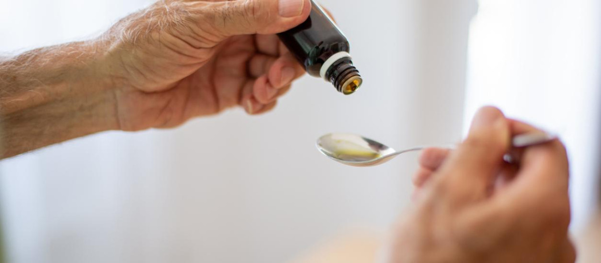 Hombre mayor vertiendo medicina en una cuchara