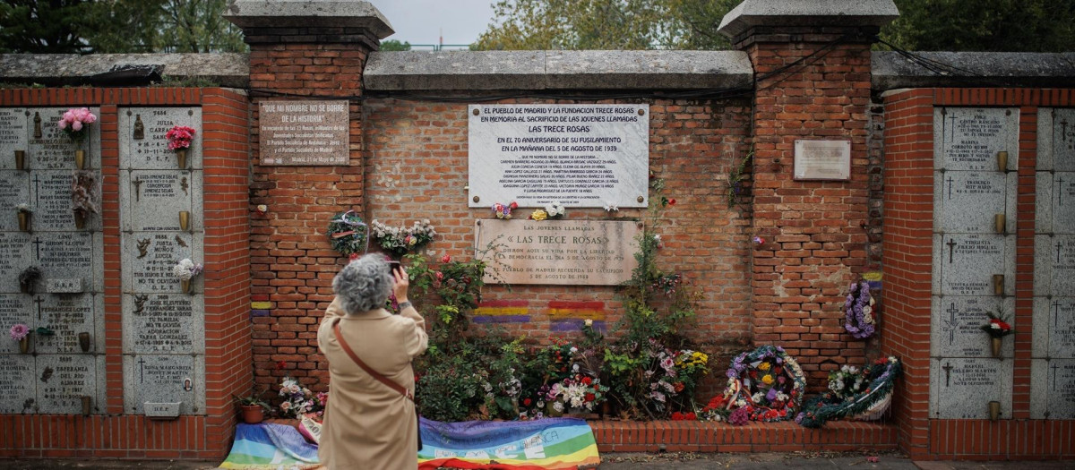 Una mujer fotografía la placa de las Trece Rosas