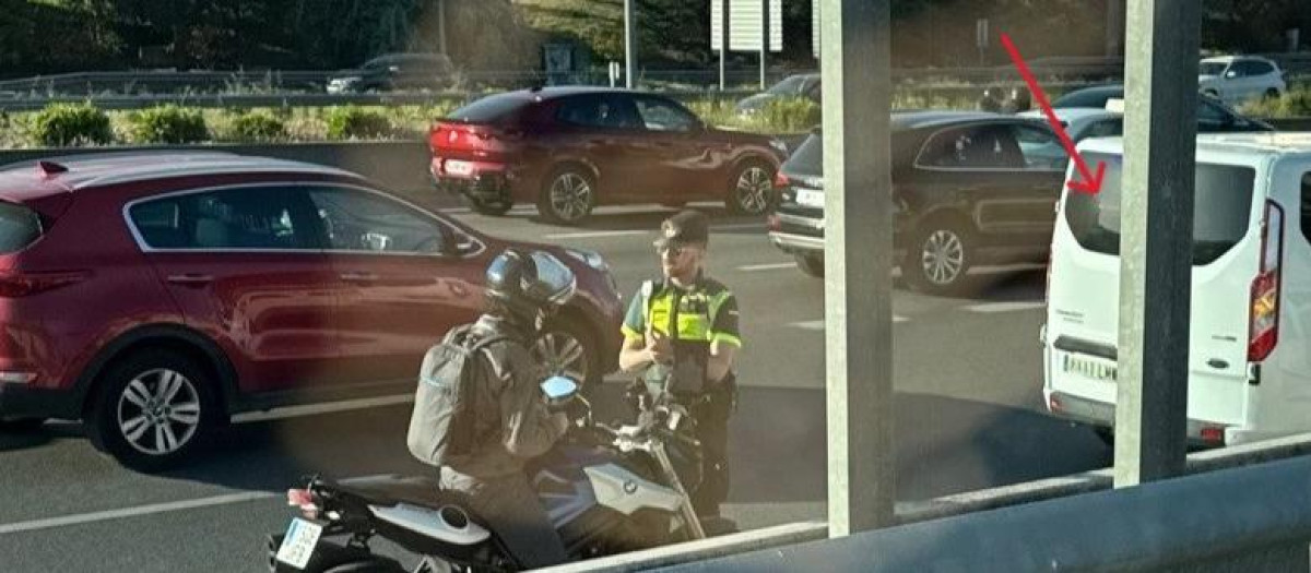 El agente sanciona al motero junto a la furgoneta, señalamos uno de los luminosos