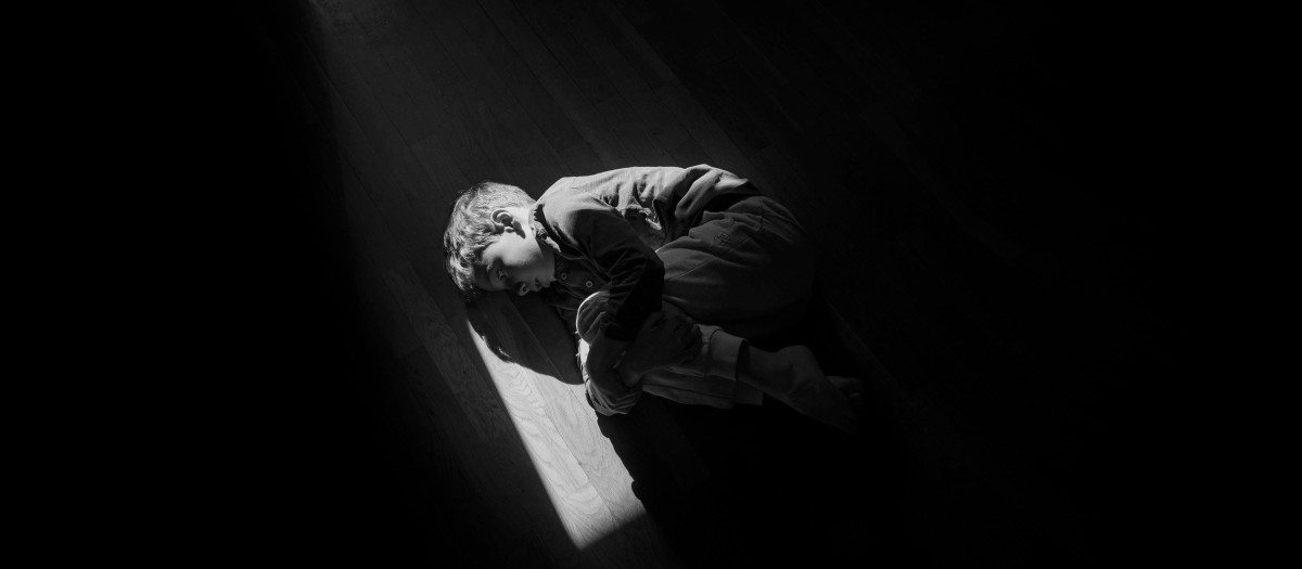 Imagen de archivo de un niño tumbado en el suelo