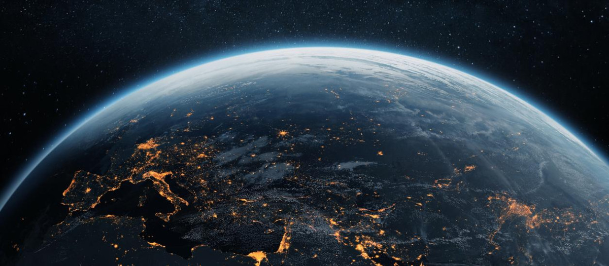 Stunning view of Earth from space at night, showing glowing city lights across Europe, the Middle East, and Asia. Planet Earth illuminated under a starry sky.