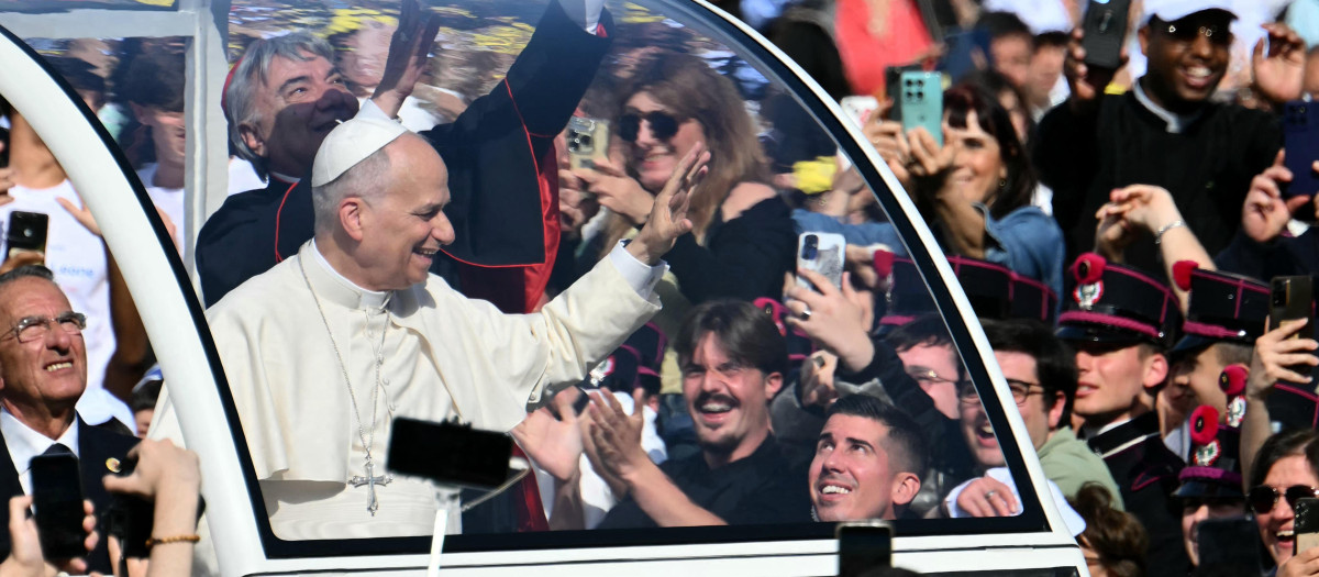 El cardenal italiano Domenico Battaglia intenta alcanzar una camiseta del Nápoles que ha caído sobre el papamóvil mientras el papa León XIV saluda a la multitud