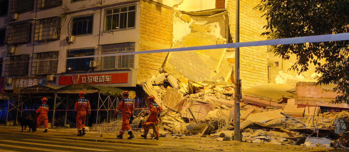 Rescatistas caminan junto a un edificio derrumbado tras un terremoto en Liuzhou