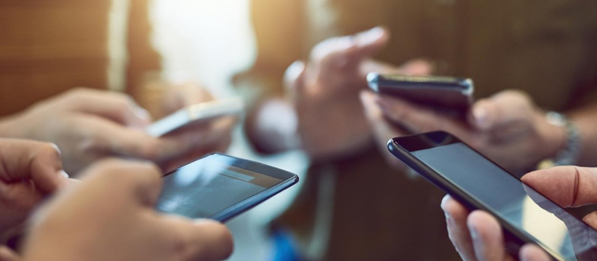 Cropped shot of a group of colleagues using their smart phones in synchronicity