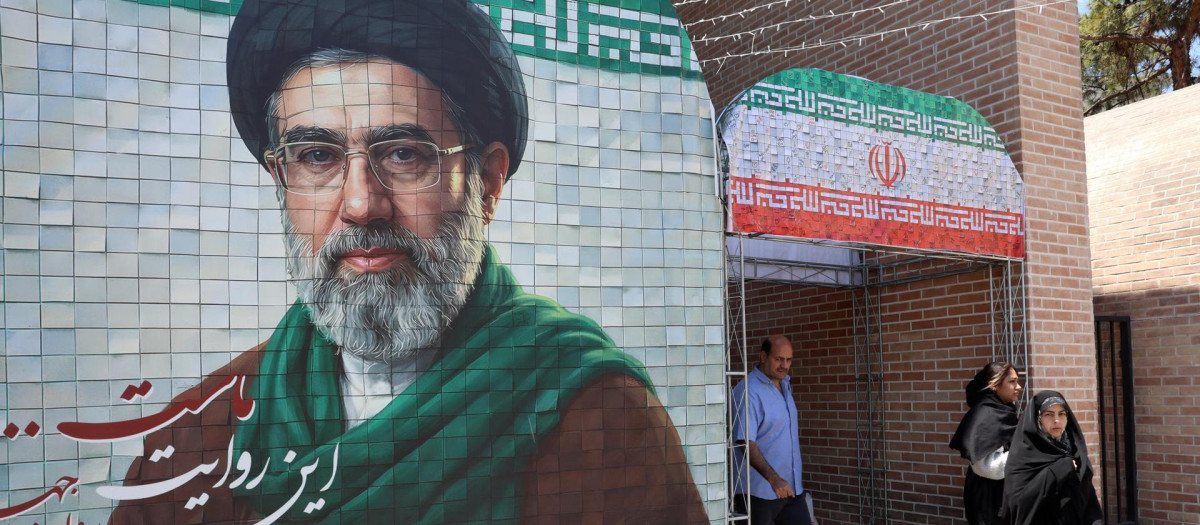 Iraníes pasan junto a una fotografía del líder supremo iraní, el ayatolá Mojtaba Jamenei, en una calle de Teherán, Irán