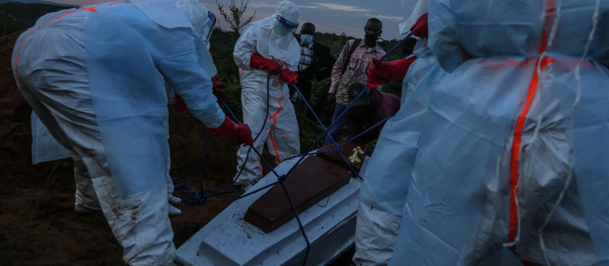 Personal médico con equipo de protección individual (EPI) entierra a un paciente fallecido en el hospital de Rwampara el 21 de mayo de 2026